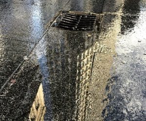 Storm drain with reflection of buildings water